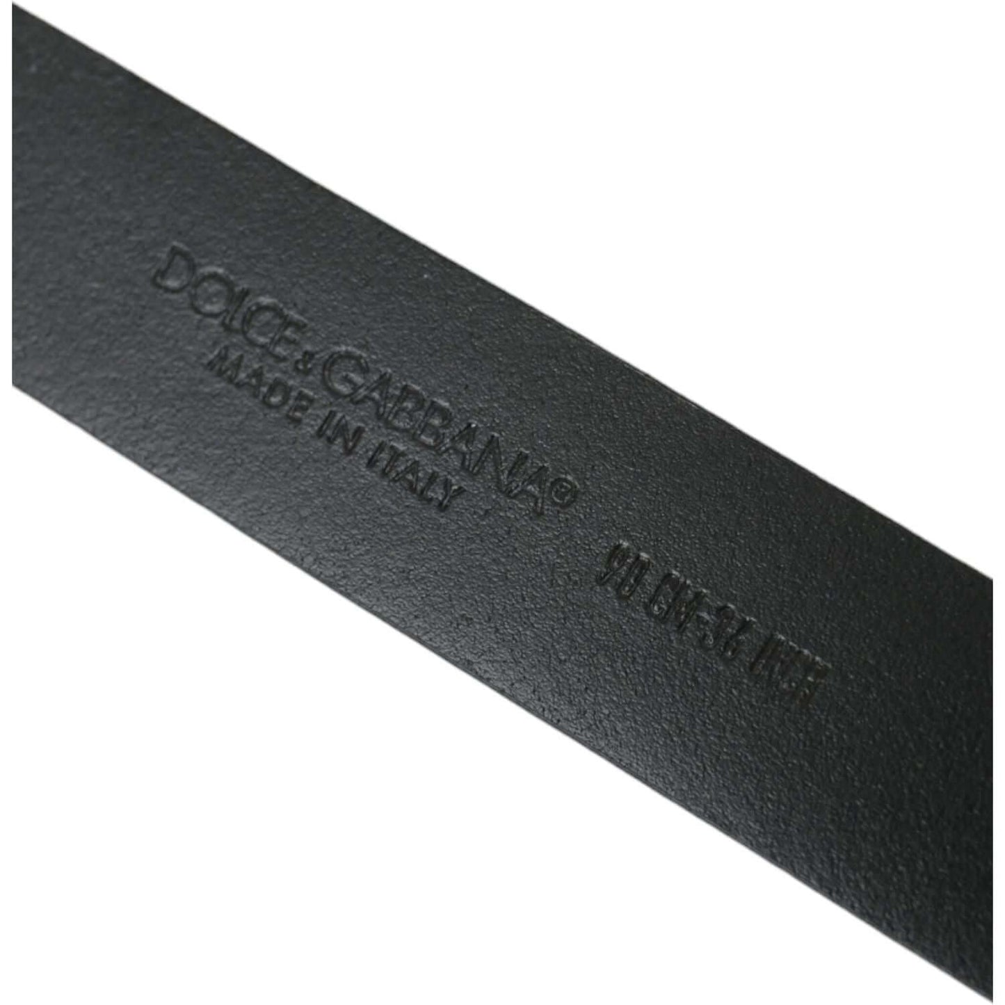 Close-up of Dolce & Gabbana logo embossed on black leather belt, showcasing 'Made in Italy' inscription.