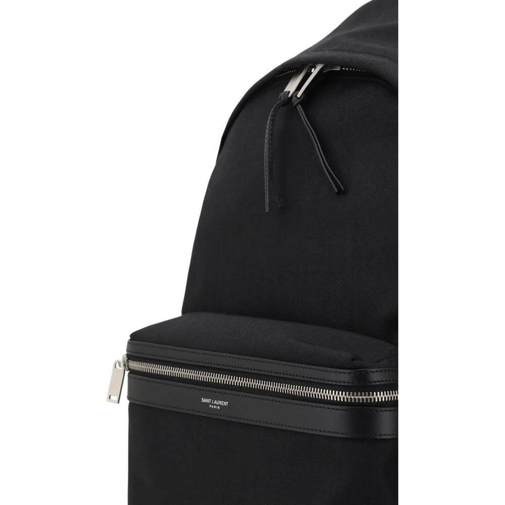 Close-up of Saint Laurent City Backpack with leather trim and silver zipper, featuring the iconic contrasting monogram.
