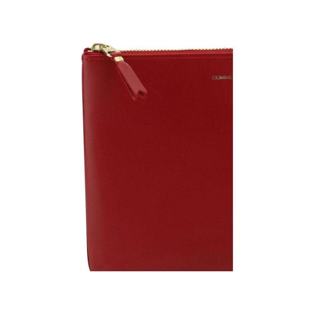 Red Comme Des Garçons Classic Leather Line pouch with gold zipper detail.